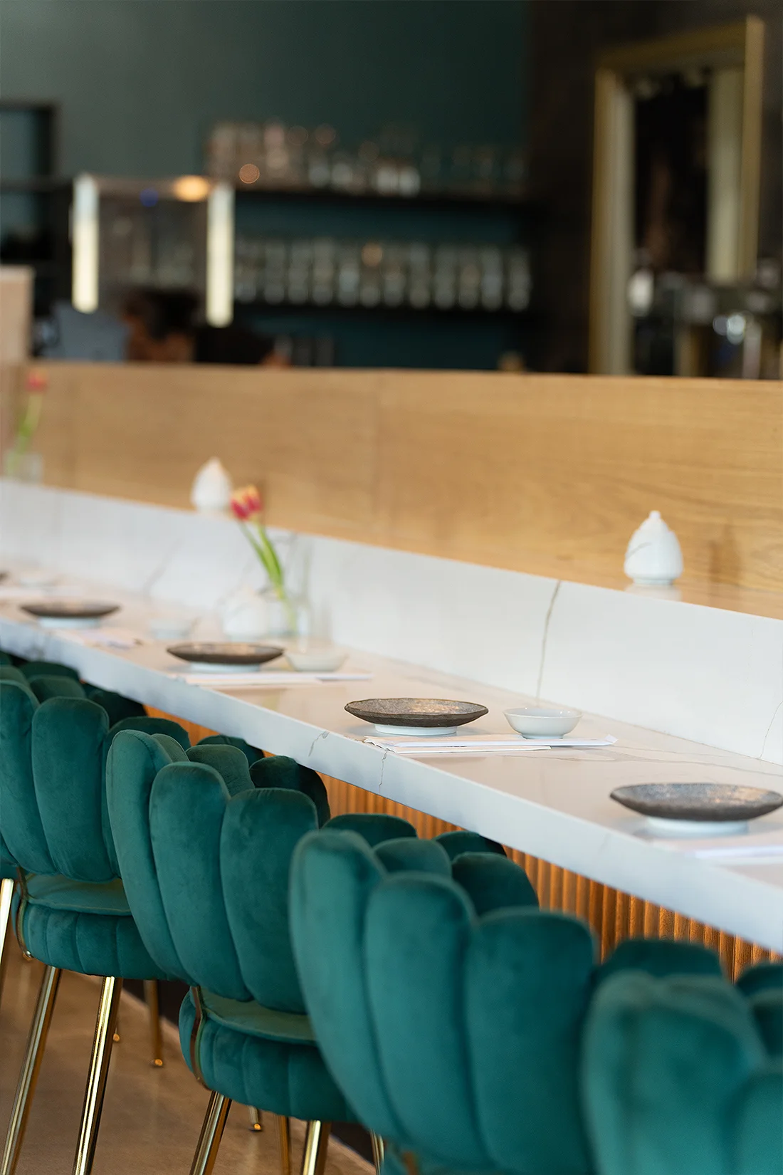 The sushi bar counter and emerald velvet stools at Fish Boon.