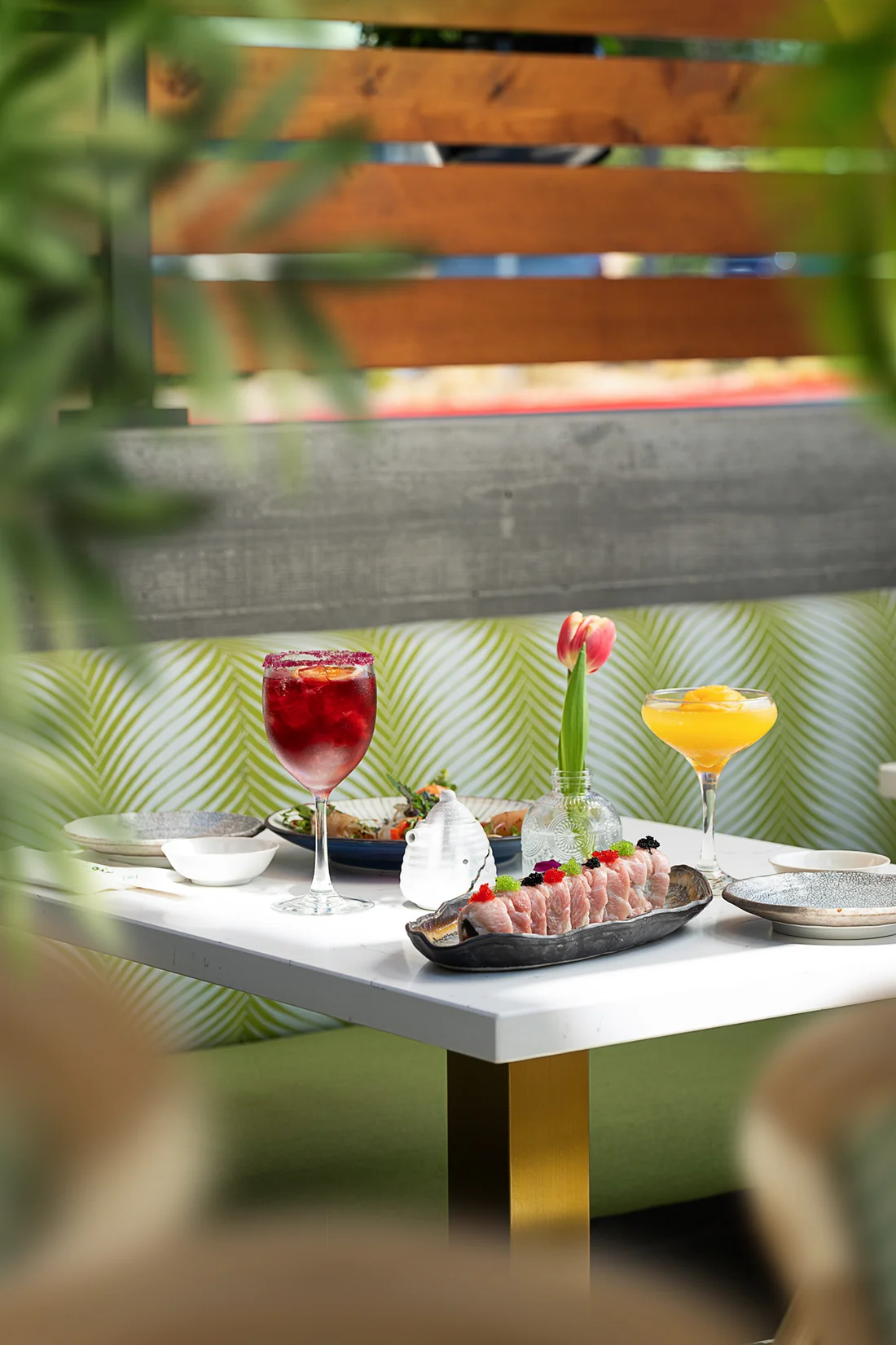 Plated sashimi and cocktails styled on a table at Fish Boon.